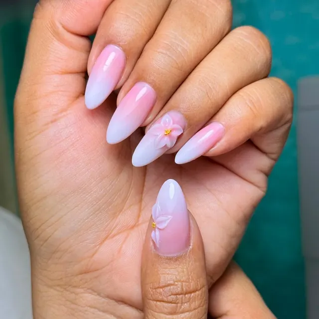 Soft pink almond extensions with a sculpted three-dimensional flower.